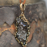 Meteorite set in bronze pendant.