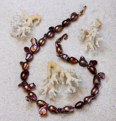Beautiful strand of large baroque fresh water pearls with purples and bronze colors.